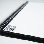 Minimalist close-up of a spiral notebook showcasing a QR code, ideal for business and education themes.