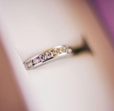 Close-up of a diamond wedding ring in soft lighting, showcasing luxury and elegance.